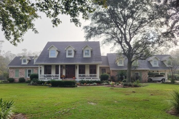 White House porch view in yard with new shingled roof done by roofing contractor Pride Roofing LLC