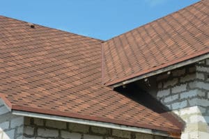 A close-up of an asphalt shingled roof valley with ventilation.