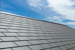 Gray tile roof of construction house with blue sky and cloud background.