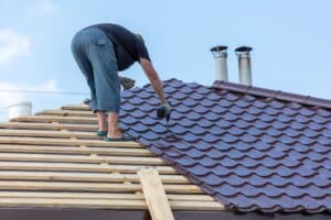 Roofing service in Hammond, LA by Pride Roofing LLC. Image of a professional roofer installing a metal roof on a commercial property, showcasing the expertise and quality services offered by Pride Roofing LLC.