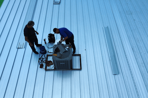 How long does a metal roof last with Pride Roofing metal roofing contractors in Hammond, LA. Image of Pride roofing contractors working on adding metal shingles to a roof on house in Hammond, La.