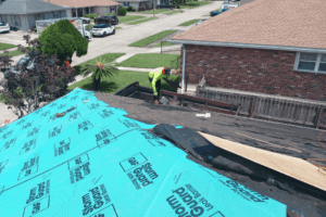 Summer roofing trends. Roofing services in Hammond, LA by Pride Roofing LLC. Image of a roofing technician working on a residential roof installation with GAF StormGuard leak barrier underlayment