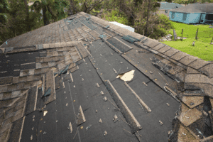 Hidden roof damage, residential roofing in Hammond, LA by Pride Roofing LLC. Image showing missing and torn asphalt shingles exposing underlayment, highlighting the need for professional roof repair and replacement services after severe weather.